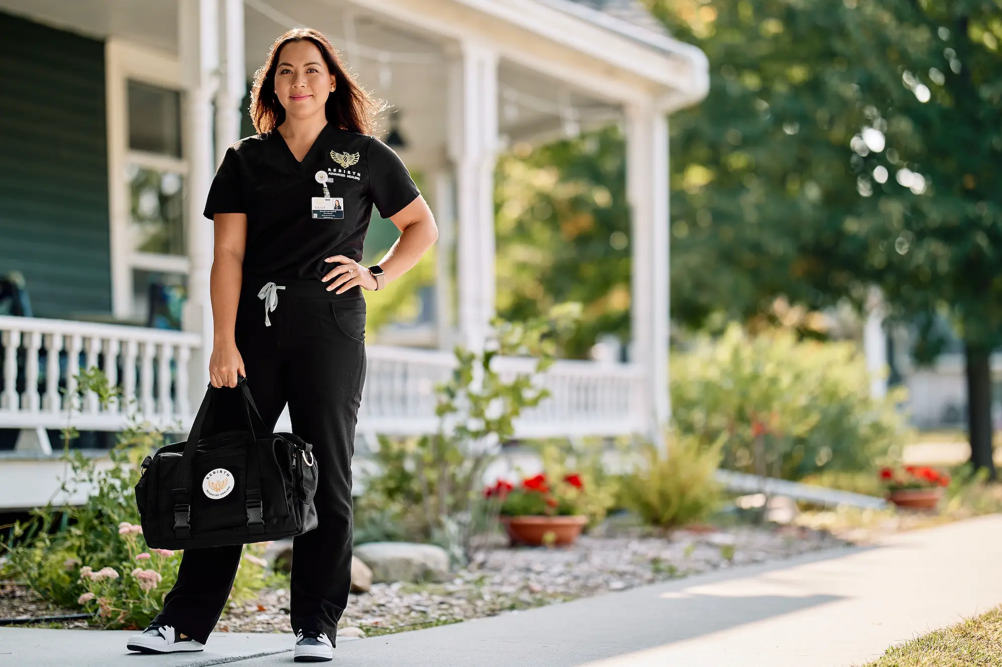 a Rebirth Advanced Healing clinician stands outside a home with her medical bag