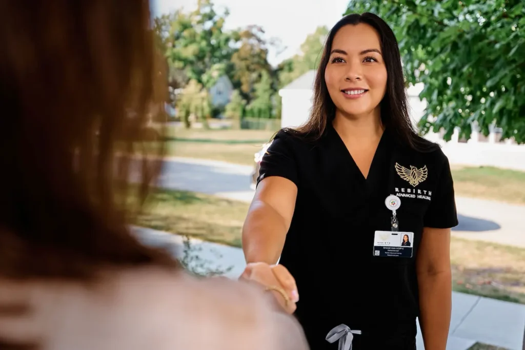 A Rebirth Advanced Healing clinician greets a family member of a chronic wound patient at their front door.