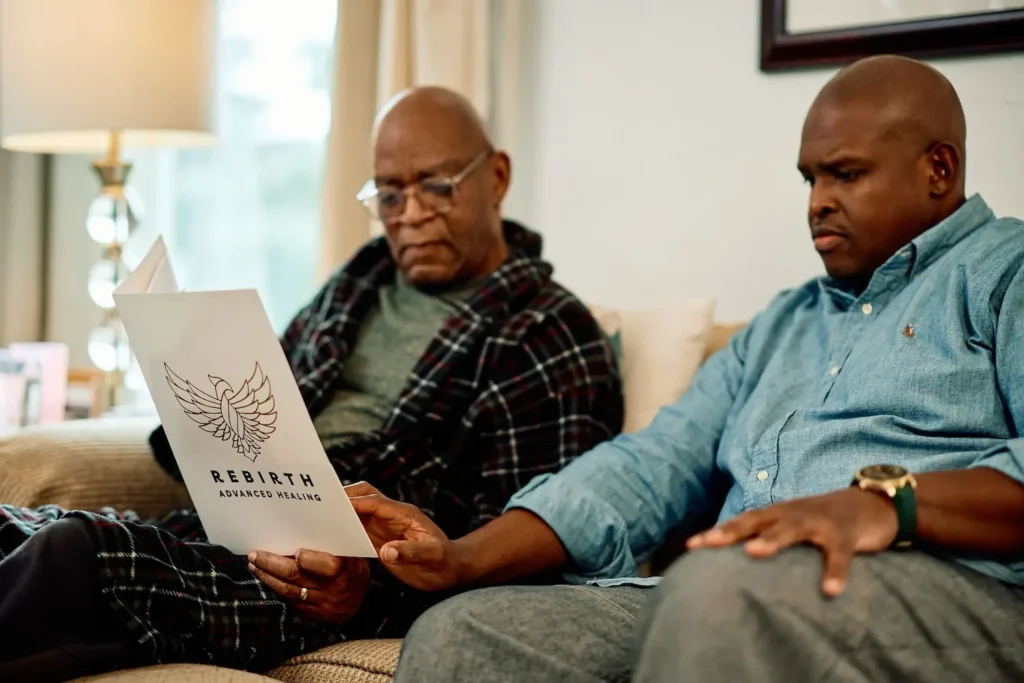 A son helps his dad read material from Rebirth Advanced Healing to help heal his chronic wound.