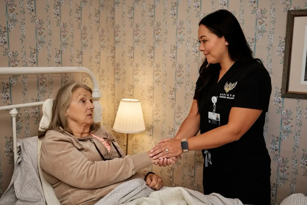 A Rebirth Advanced Healing clinician comforts a chronic wound patient in her bed.