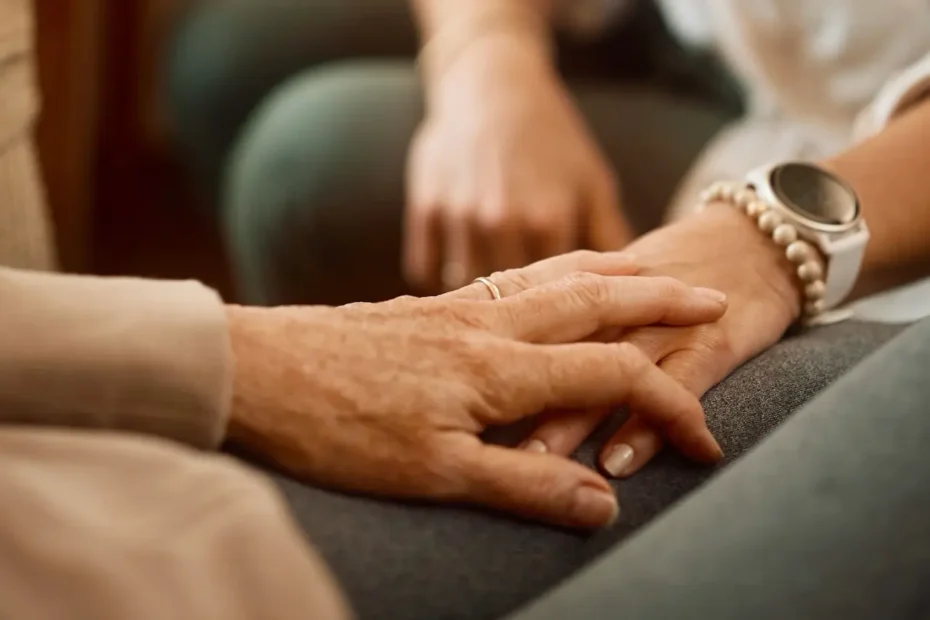 A comforting hand touches a chronic wound patient's hand.
